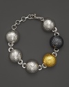A modern bracelet with a mix of hammered domes in sterling silver, blackened silver and yellow gold from Gurhan.