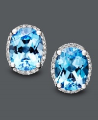 Like staring into two clear, blue pools. These bright earrings feature oval-cut blue topaz (4 ct. t.w.) and round-cut diamond (1/8 ct. t.w.). Crafted in 14k white gold. Approximate diameter: 1/2 inch. Like staring into two clear, blue pools. These bright earrings feature oval-cut blue topaz (4 ct. t.w.) and round-cut diamond (1/8 ct. t.w.). Crafted in 14k white gold. Approximate diameter: 1/2 inch.
