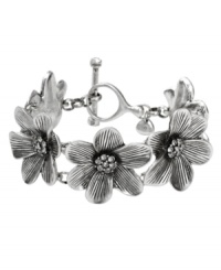 Let your style bloom this season! Fossil's station bracelet boasts sculpted flowers accented by clear crystal accents. Crafted in silver tone mixed metal. A toggle closure holds everything together. Approximate length: 8 inches. Let your style bloom this season! Fossil's station bracelet boasts sculpted flowers accented by clear crystal accents. Crafted in silver tone mixed metal. A toggle closure holds everything together. Approximate length: 8 inches.