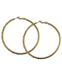 A stylish must-have. These clutchless hoop earrings from GUESS feature a diamond dust design with glass stones. Crafted in gold tone mixed metal. Approximate diameter: 2-1/2 inches. A stylish must-have. These clutchless hoop earrings from GUESS feature a diamond dust design with glass stones. Crafted in gold tone mixed metal. Approximate diameter: 2-1/2 inches.