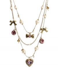 In the mood for love? Show it in Betsey Johnson's sweet styles. This illusion-style necklace features three layers of pink crystal hearts, glass pearls, and shiny bows. Setting and chains crafted in antique gold tone mixed metal. Approximate length: 15-1/2 inches + 3-inch extender.