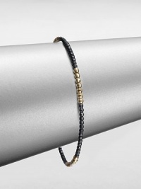 A simple chic piece that features faceted beads in blackened sterling silver accented with four, 14k gold beaded sections. Blackened sterling silver14k goldDiameter, about 2.5Slip-on styleMade in USA A simple chic piece that features faceted beads in blackened sterling silver accented with four, 14k gold beaded sections. Blackened sterling silver14k goldDiameter, about 2.5Slip-on styleMade in USA