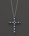 Diamonds and sapphires in a 14K white gold cross pendant on a fine chain.