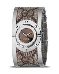 A beige/ebony Gg fabric bangle cuff watch from the Gucci Twirl collection. With logo printed fabric bangle and a stainless steel frame. Brown sun-brushed dial and jewelry clasp. A beige/ebony Gg fabric bangle cuff watch from the Gucci Twirl collection. With logo printed fabric bangle and a stainless steel frame. Brown sun-brushed dial and jewelry clasp.