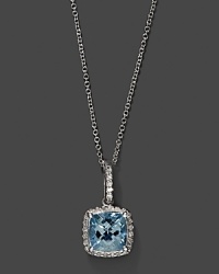 Diamonds frame a cushion cut aquamarine, set in 14K white gold. Diamonds frame a cushion cut aquamarine, set in 14K white gold.