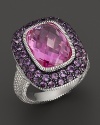 A sterling silver ring with large cushion-cut pink corundum stone and wide amethyst pave frame. By Judith Ripka.