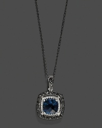 Black and white diamonds frame a faceted London blue topaz, set in 14K white gold with a rhodium chain. Black and white diamonds frame a faceted London blue topaz, set in 14K white gold with a rhodium chain.