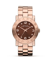 Clock in with MARC BY MARC JACOBS. This plated stainless steel watch flaunts a bold bracelet design with rose gold accents for timeless allure. Clock in with MARC BY MARC JACOBS. This plated stainless steel watch flaunts a bold bracelet design with rose gold accents for timeless allure.