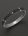 Faceted black sapphires, punctuated by diamonds, set in a dazzling 18K white gold band. By Roberto Coin.