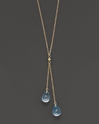 Twin blue topaz briolettes sparkle from this 14K yellow gold lariat necklace. Twin blue topaz briolettes sparkle from this 14K yellow gold lariat necklace.