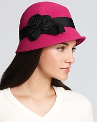 Bright and statement-making, this fuchsia fedora features an asymmetrical brim and pretty ribbon roses.