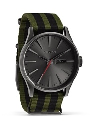 Nixon shows it's stripes with this military-inspired watch. A perfect fusion of performance and commanding style, it flaunts a flexible a nylon bracelet, 100 meter water resistance, and custom colored oxide face. Nixon shows it's stripes with this military-inspired watch. A perfect fusion of performance and commanding style, it flaunts a flexible a nylon bracelet, 100 meter water resistance, and custom colored oxide face.