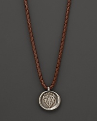Silver Gucci charm on a braided brown natural leather necklace. Silver Gucci charm on a braided brown natural leather necklace.