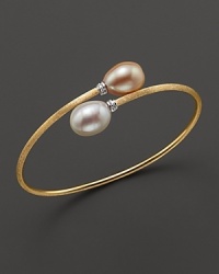 Gleaming peach and white freshwater pearls cap this 18K yellow gold bangle, from the Africa Pearl Collection. Gleaming peach and white freshwater pearls cap this 18K yellow gold bangle, from the Africa Pearl Collection.