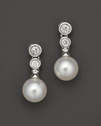 Two bezel-set diamond studs with cultured Akoya pearls; in a linear design. Two bezel-set diamond studs with cultured Akoya pearls; in a linear design.