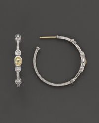 Faceted, oval-shaped canary crystals, flanked by hearts, bring romantic glamour to classic sterling silver hoop earrings. Faceted, oval-shaped canary crystals, flanked by hearts, bring romantic glamour to classic sterling silver hoop earrings.