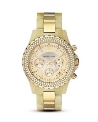A gleaming gold tone bezel embellished with crystals offsets a mother of pearl dial in this luxe timepiece from MICHAEL Michael Kors. A gleaming gold tone bezel embellished with crystals offsets a mother of pearl dial in this luxe timepiece from MICHAEL Michael Kors.