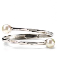 An understated offering from Majorica, this bangle features overlapping contoured sterling silver bands with man-made pearl accents. An understated offering from Majorica, this bangle features overlapping contoured sterling silver bands with man-made pearl accents.
