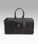 Tessuto nylon duffel bag with saffiano leather trim. Removable/adjustable shoulder strap Double short saffiano leather top handles Top zip closure Prada jacquard lining 21W X 11½H X 9½D Made in Italy 