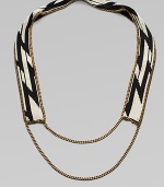 A dramatic look formed of black and white beads in a striking tribal design on a flat strap, framed and finished with bold golden chains.GlassGoldtoneCotton backingLength, about 20¾Imported
