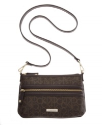 Keep things casual yet classy with this monogram crossbody by Calvin Klein. Goldtone hardware and a signature plaque at front give this travel-ready design a timeless appeal. Keep things casual yet classy with this monogram crossbody by Calvin Klein. Goldtone hardware and a signature plaque at front give this travel-ready design a timeless appeal.