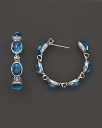 Blue topaz stones give a lasting impression on Di MODOLO's standout multi stone hoop earrings. Blue topaz stones give a lasting impression on Di MODOLO's standout multi stone hoop earrings.