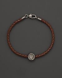 Silver Gucci charm on a braided brown natural leather bracelet. Silver Gucci charm on a braided brown natural leather bracelet.