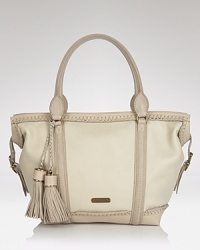 In soft, pale leather. this Burberry tote lends iconic style with modern details--whipstitched trim and oversized tassels lend forward flair. In soft, pale leather. this Burberry tote lends iconic style with modern details--whipstitched trim and oversized tassels lend forward flair.