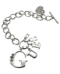 Strike up the brand. This logo and heart bracelet from GUESS is crafted from silver-tone mixed metal, with glass crystals adding a lustrous touch. Item comes packaged in a signature GUESS Gift Box. Approximate length: 7-1/2 inches. Approximate diameter: 1-1/2 inches. Approximate drop: 1 inch. Strike up the brand. This logo and heart bracelet from GUESS is crafted from silver-tone mixed metal, with glass crystals adding a lustrous touch. Item comes packaged in a signature GUESS Gift Box. Approximate length: 7-1/2 inches. Approximate diameter: 1-1/2 inches. Approximate drop: 1 inch.