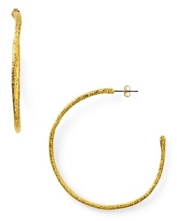 Designer Alexis Bittar plays rough with these textured gold plated hoop earrings, boasting a simple shape and faceted finish. Designer Alexis Bittar plays rough with these textured gold plated hoop earrings, boasting a simple shape and faceted finish.