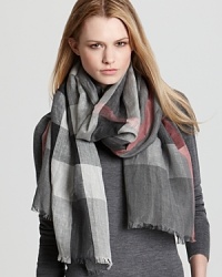 An oversized check pattern in gray and pink gives this lightweight Burberry scarf a cool, seasonal update. An oversized check pattern in gray and pink gives this lightweight Burberry scarf a cool, seasonal update.