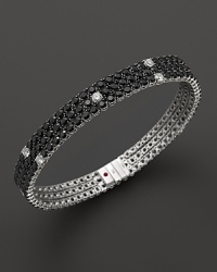 Faceted black sapphires, punctuated by diamonds, set in a dazzling 18K white gold band. By Roberto Coin.