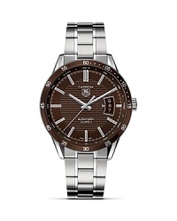 TAG Heuer's Carrera series has epitomized racing style since its introduction nearly 50 years ago. This watch features a Calibre 5 automatic movement with an expanded date window at three o'clock. The brown dial features a Clous de Paris textured design with a matching brown aluminum bezel. The 39mm steel case is mated to a steel bracelet with alternating fine-brushed and polished steel elements. TAG Heuer's Carrera series has epitomized racing style since its introduction nearly 50 years ago. This watch features a Calibre 5 automatic movement with an expanded date window at three o'clock. The brown dial features a Clous de Paris textured design with a matching brown aluminum bezel. The 39mm steel case is mated to a steel bracelet with alternating fine-brushed and polished steel elements.
