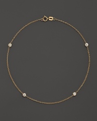 Diamond bezels sparkle from the stations on this dainty 14K yellow gold ankle bracelet. Diamond bezels sparkle from the stations on this dainty 14K yellow gold ankle bracelet.