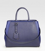A roomy style in luxurious leather and matching coated twill with signature hardware.Double coated twill top handles, 5½ dropDetachable leather shoulder strap, 13¼ dropSnap strap closureProtective metal feetThree inner compartmentsTwo inside open pocketsFully lined14W X 10¾H X 6DMade in Italy
