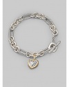 From the Cable Heart Collection. A bold chain, combining smooth and cable links, holds a lovely cable heart charm, framed in 18k gold. Sterling silver and 18k yellow gold Length, about 7½ Toggle closure Imported