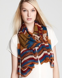 With a tribal print in seasonal hues and a bold striped border, this Theodora & Callum oblong scarf is a work of art. With a tribal print in seasonal hues and a bold striped border, this Theodora & Callum oblong scarf is a work of art.