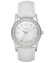 Refined and tranquil, this timepiece from DKNY soothes the mind with each passing second. Crafted of white leather strap and round stainless steel case. Bezel embellished with 48 clear crystal accents. White mother-of-pearl dial features silver tone numerals at three, six, nine and twelve o'clock, stick indices, minute track, silver tone three hands and logo at twelve o'clock. Quartz movement. Water resistant to 50 meters. Two-year limited warranty. Refined and tranquil, this timepiece from DKNY soothes the mind with each passing second. Crafted of white leather strap and round stainless steel case. Bezel embellished with 48 clear crystal accents. White mother-of-pearl dial features silver tone numerals at three, six, nine and twelve o'clock, stick indices, minute track, silver tone three hands and logo at twelve o'clock. Quartz movement. Water resistant to 50 meters. Two-year limited warranty.