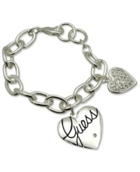 Fall in love with fashion. This lovely style from GUESS features a heart charm with jet epoxy logo and a smaller heart with shiny pave stones. Crafted in silver tone mixed metal. Approximate length: 7-1/2 inches. Fall in love with fashion. This lovely style from GUESS features a heart charm with jet epoxy logo and a smaller heart with shiny pave stones. Crafted in silver tone mixed metal. Approximate length: 7-1/2 inches.