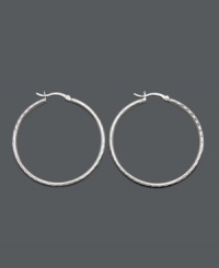 Traditional hoops with a cutting edge design. Set in sterling silver, these large hoops feature diamond-cut embellishments at the edges. Approximate diameter: 2 inches. Traditional hoops with a cutting edge design. Set in sterling silver, these large hoops feature diamond-cut embellishments at the edges. Approximate diameter: 2 inches.