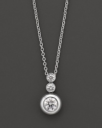 White gold bezel-set diamond necklace in three-stone drop design. With signature ruby accent. Designed by Roberto Coin. White gold bezel-set diamond necklace in three-stone drop design. With signature ruby accent. Designed by Roberto Coin.