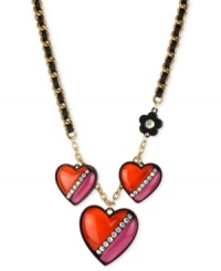 Hearts in the right place. Betsey Johnson's necklace is crafted from gold-tone mixed metal with black grosgrain ribbon. Three heart charms and a flower one, too, are adorned with glass crystal accents for a lustrous touch. Approximate length: 16 inches + 3-inch extender. Approximate drop: 1-3/4 inches.