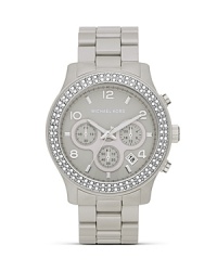 Surrender to sparkle with this Swarovski crystal-rimmed watch from MICHAEL Michael Kors, boasting an oversized case and pace-setting chronograph movement. Surrender to sparkle with this Swarovski crystal-rimmed watch from MICHAEL Michael Kors, boasting an oversized case and pace-setting chronograph movement.