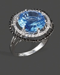 Diamonds and black diamonds frame a faceted blue topaz, set in 14K white gold. Diamonds and black diamonds frame a faceted blue topaz, set in 14K white gold.